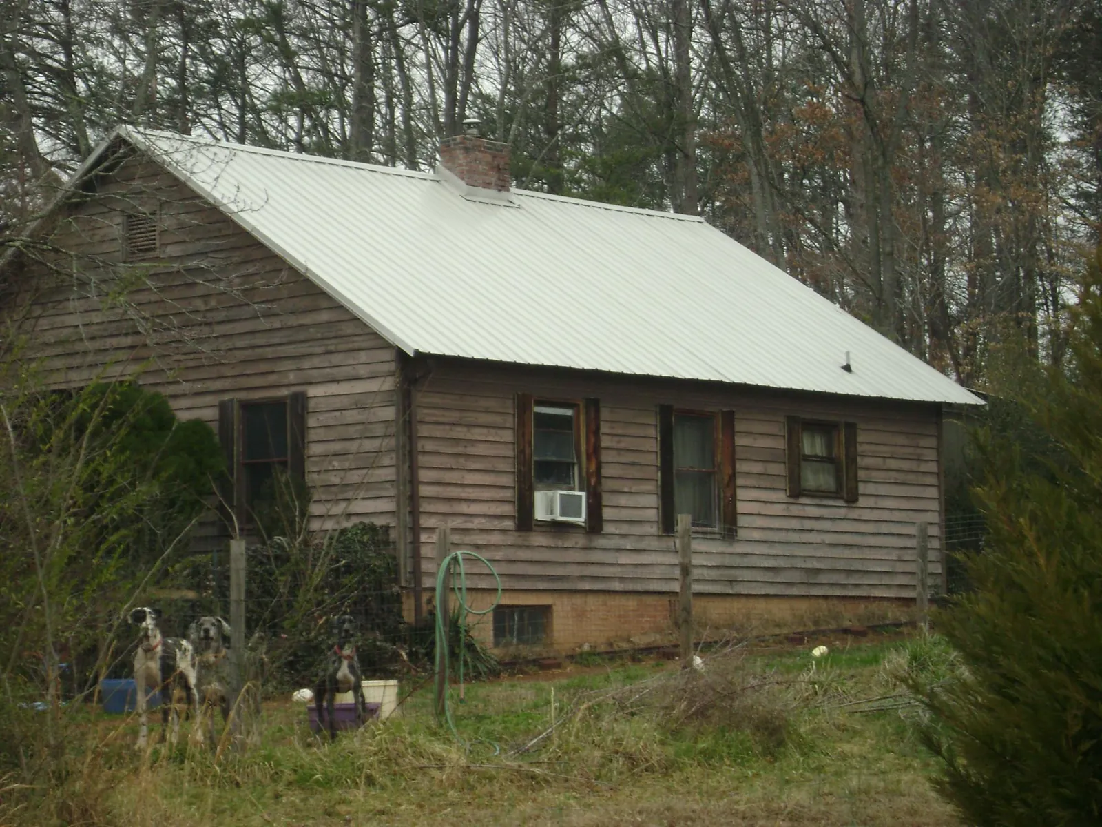 White metal roof on an old wood sided farmhouse, from a Metal Roof Installation job in Winfred